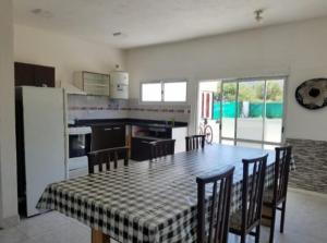 a kitchen with a table and some chairs and a kitchen with a table at Casa om in San Roque