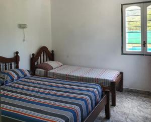 Casa om في San Roque: سريرين يجلسون بجانب بعض في غرفة النوم