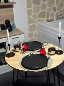 een tafel met twee zwarte platen en kaarsen erop bij Msroom in Le Val-dʼAjol