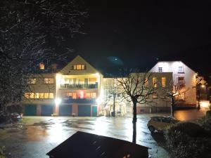 un bâtiment dans un parking la nuit dans l'établissement Hotel Landgasthof Simon, à Waldrach
