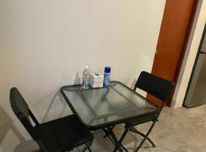 uma mesa de vidro com duas cadeiras e duas garrafas em La Ventana Apartments Biznaga 2 em La Ventana