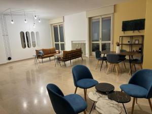 ein Wohnzimmer mit blauen Stühlen und einem Tisch in der Unterkunft FEEL - Bellavista Suites in Bergamo