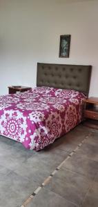 Schlafzimmer mit einem Bett mit einer rosa und weißen Bettdecke in der Unterkunft Espectacular casa en country in Guernica