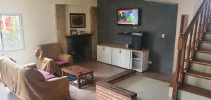 ein Wohnzimmer mit 2 Stühlen und einem TV in der Unterkunft Espectacular casa en country in Guernica