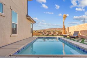 ein Swimmingpool mit Liegestühlen und einer Palme in der Unterkunft Paseos 1121 Sleeps 15, Private Hot Tub, Near Sand Hollow, and Quail Lake in Washington