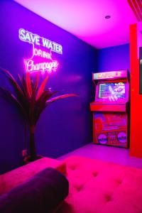 a bedroom with a neon sign that says save water drink champagne at Capsule Boogie-Woogie - JACUZZI - SAUNA - BILLARD - JEUX - ECRAN GÉANT - FILET SUSPENDU - NETFLIX in La Louvière