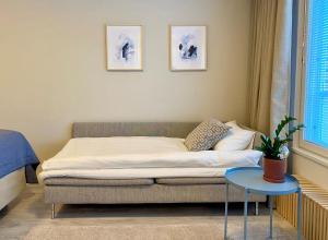 a bed in a room with a couch and a table at Bright City Apartment with free Car Park and Wi-Fi in Vaasa