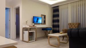 a living room with a couch and a tv at Mavili Suites in Bostancı