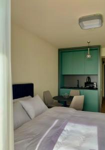 1 dormitorio con cama, mesa y cocina en Orbi Beach Tower, en Batumi