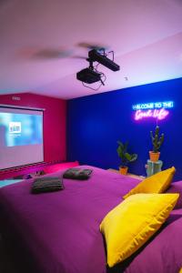 een slaapkamer met een groot bed en een projectiescherm bij Capsule Boogie-Woogie - JACUZZI - SAUNA - BILLARD - JEUX - ECRAN GÉANT - FILET SUSPENDU - NETFLIX in La Louvière