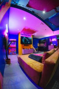 um quarto com uma cama grande e iluminação roxa em Capsule Boogie-Woogie - JACUZZI - SAUNA - BILLARD - JEUX - ECRAN GÉANT - FILET SUSPENDU - NETFLIX em La Louvière