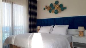 a bedroom with a white bed with a blue headboard at Mavili Suites in Bostancı