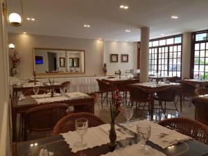 a restaurant with tables and chairs and a mirror at Caetité Palace Hotel in Caetité
