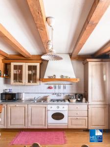 a kitchen with white appliances and wooden cabinets at Dolomites Stunning View & Garden in San Vito di Cadore
