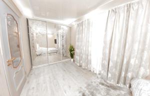 um quarto com um espelho, uma cama e uma janela em Центр Яворницкого с Джакузи em Dnipro