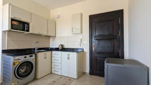 a small kitchen with a washing machine and a door at Golf Heights Resort - Sea and Mountain View - Free WIFI - Sharm El Sheikh in Sharm El Sheikh