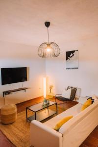 uma sala de estar com um sofá branco e uma televisão em Beautiful Olive's cave house em Lomo de Arico
