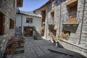 a stone building with potted plants and flowers in a courtyard at Apartamentos Casa Riu in Sahun