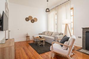 ein Wohnzimmer mit einem Sofa und einem Tisch in der Unterkunft Appartement spacieux et chaleureux coeur de ville in Chambéry