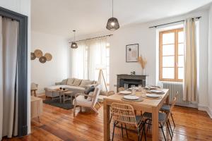 Appartement spacieux et chaleureux coeur de ville في شامبيري: غرفة معيشة مع طاولة وكراسي خشبية
