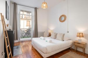 Appartement spacieux et chaleureux coeur de ville في شامبيري: غرفة معيشة مع أريكة بيضاء ونافذة