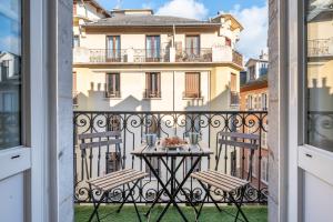 a table on the balcony of a building at Appartement spacieux et chaleureux coeur de ville in Chambéry