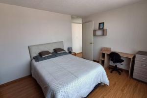 een slaapkamer met een groot bed en een bureau bij La mejor vista de la ciudad y el confort deseado!! in Arequipa