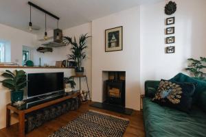 a living room with a green couch and a fireplace at Unique Cottage in the heart of Ulverston in Ulverston