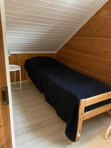 ein Schlafzimmer mit einem Bett in einem Holzzimmer in der Unterkunft Levi Piippo 2 in Kittilä