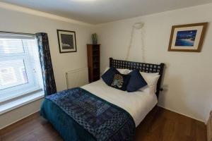 um quarto com uma cama com almofadas e uma janela em Unique Cottage in the heart of Ulverston em Ulverston