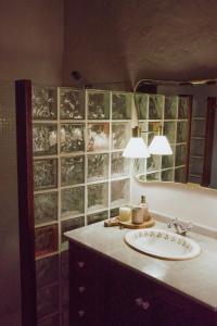uma casa de banho com um lavatório e um espelho em Beautiful Olive's cave house em Lomo de Arico