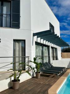 a white house with a deck with a swimming pool at Villa Son Blanc 6 in Sa Caleta