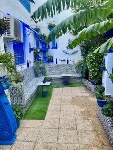 a courtyard in a house with blue walls and plants at The Blue and White Perle in Sidi Bou Saïd