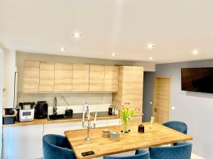 eine Küche mit einem Holztisch und blauen Stühlen in der Unterkunft Bel Appartement terrasse privée à 5 minutes du métro in Romainville + 24 Fotos