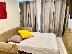 ein Bett mit einem gelben Kissen darauf in der Unterkunft Bel Appartement terrasse privée à 5 minutes du métro in Romainville