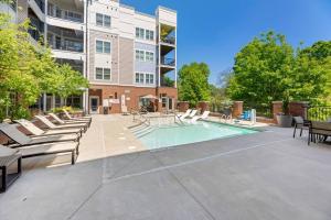 Una piscina con tumbonas y un edificio. en DT Charm Apt with Pool,Gym,Wine,WKSpace, Free Parking, en Charlotte