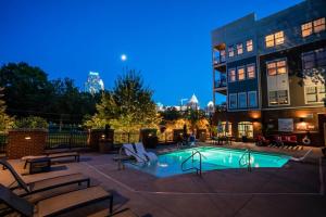 una piscina con bancos y un edificio en DT Charm Apt with Pool,Gym,Wine,WKSpace, Free Parking, en Charlotte