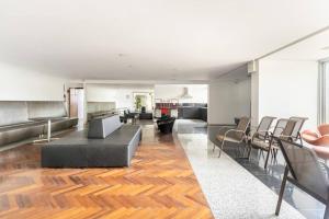uma sala de estar com um sofá e cadeiras em Flat lindo e moderno em Belo Horizonte