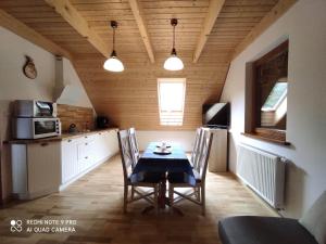 a kitchen with a table and chairs in a room at Dworek. Lubkowo in Lubkowo