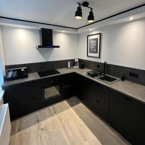 uma cozinha com armários pretos e uma bancada em Le Ravel Maison em Burg-Reuland
