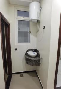een badkamer met een wastafel en een raam bij شقق مفروسة المشور in Laayoune