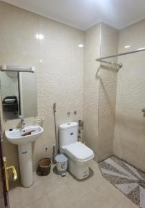 a bathroom with a toilet and a sink at شقق مفروسة المشور in Laayoune