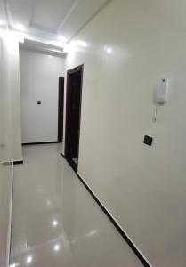 ein weißes Zimmer mit einer Tür und einer weißen Wand in der Unterkunft شقق مفروسة المشور in El Aaiún