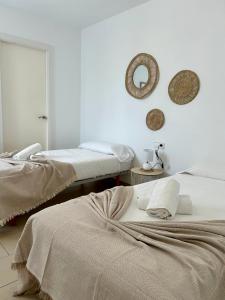 a bedroom with two beds and a mirror on the wall at Villa Son Blanc 6 in Sa Caleta