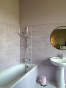 y baño con bañera, lavabo y espejo. en L'Arcane Du Bellay en Montreuil-Bellay