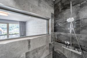 a bathroom with a shower with a window at Hotel Tyrolerhof in Sölden