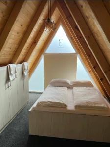 Bett in einem Zimmer mit einem großen Fenster in der Unterkunft Bungalow Damiano's in Mrkonjić Grad