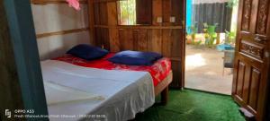 a small bedroom with a bed and a door to a yard at Sok Mean Bungalows in Koh Rong Sanloem