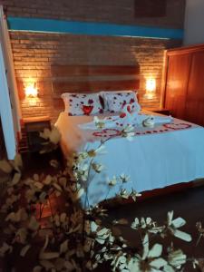 a bedroom with a bed with white sheets and pillows at Chalé da Sorte in Gonçalves