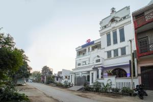 un edificio blanco al lado de una calle en OYO Flagship 63319 Hotel Corinthian, en Rudrapur